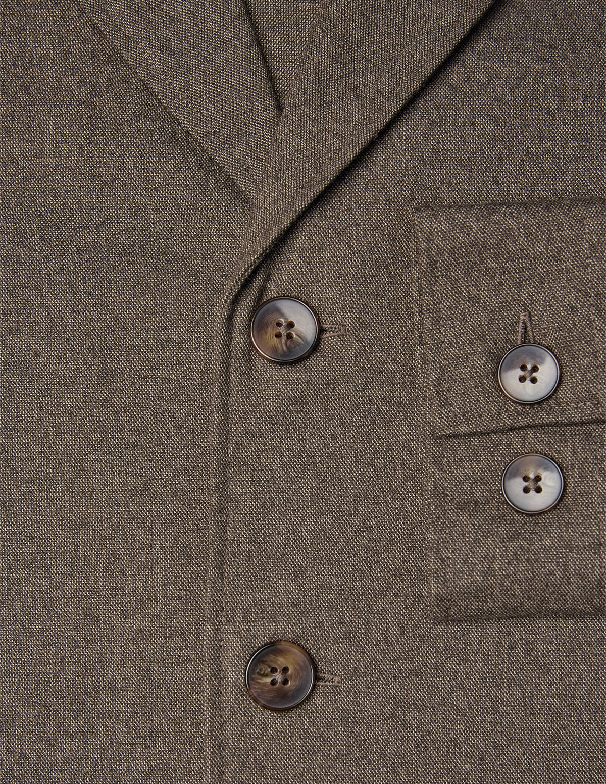 Nahaufnahme eines Atelier Overshirt in Dunkelbeige mit gebrochener Köperbindung, gekerbtem Revers, Brusttasche und dunklen Knöpfen.