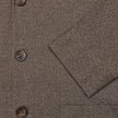 Atelier-Overshirt in Dunkelbeige aus gebrochenem Twill mit drei braunen Knöpfen und einer Tasche, das das minimalistische skandinavische Design widerspiegelt.