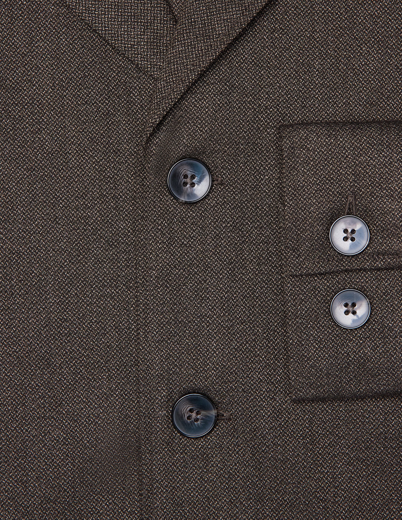 Nahaufnahme des dunkelbraunen Atelier-Overshirts aus gebrochenem Twill mit zwei Knöpfen vorne und zwei passenden Knöpfen an den Ärmelbündchen.