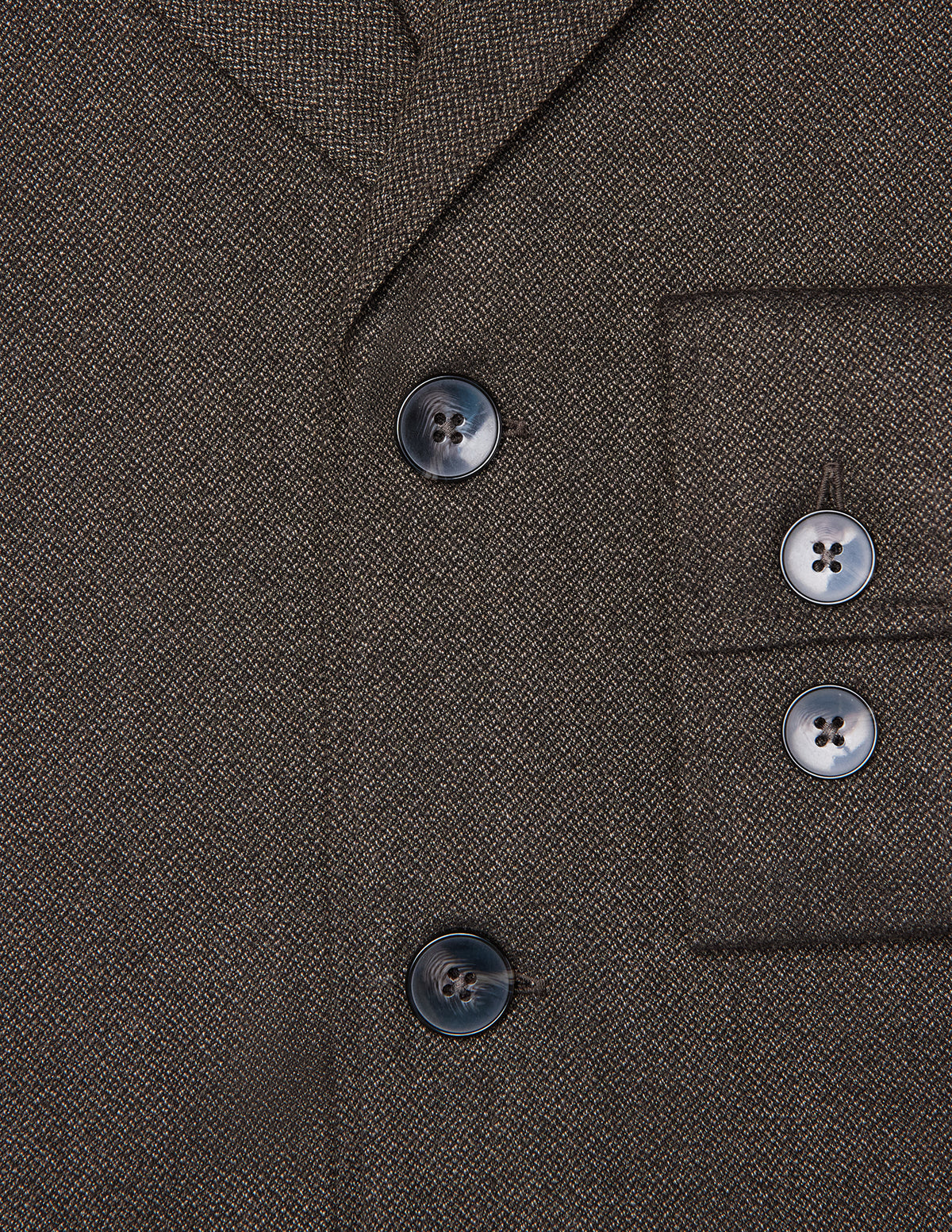 Nahaufnahme des dunkelbraunen Atelier-Overshirts aus gebrochenem Twill mit zwei Knöpfen vorne und zwei passenden Knöpfen an den Ärmelbündchen.