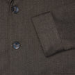 Nahaufnahme eines Atelier Overshirt Dark Brown aus einem strukturierten, dunkelbraunen, gebrochenen Köpergewebe mit drei dunklen Knöpfen.