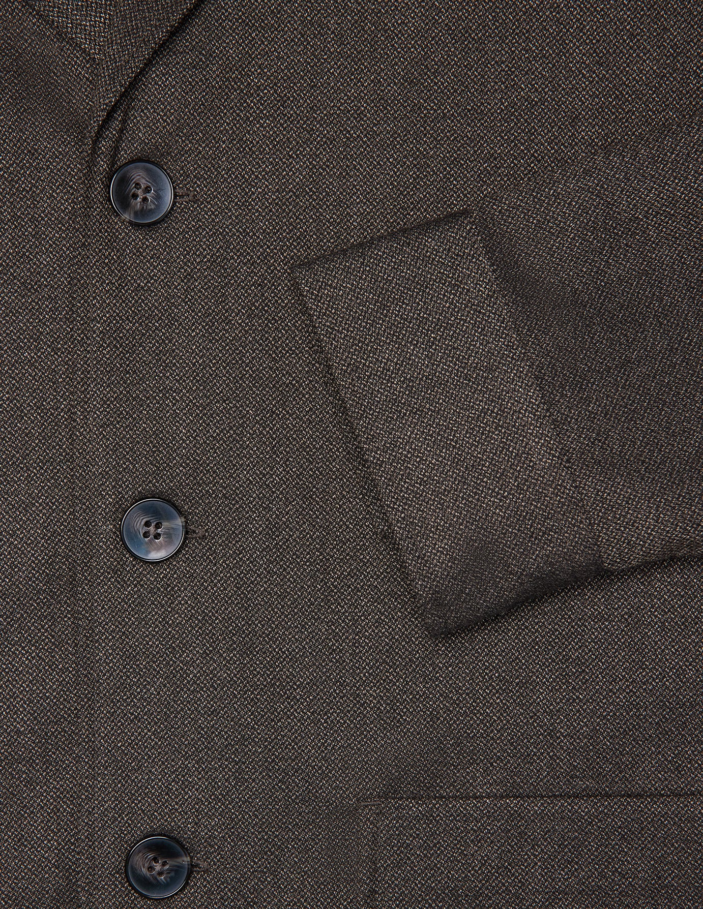 Nahaufnahme eines Atelier Overshirt Dark Brown aus einem strukturierten, dunkelbraunen, gebrochenen Köpergewebe mit drei dunklen Knöpfen.