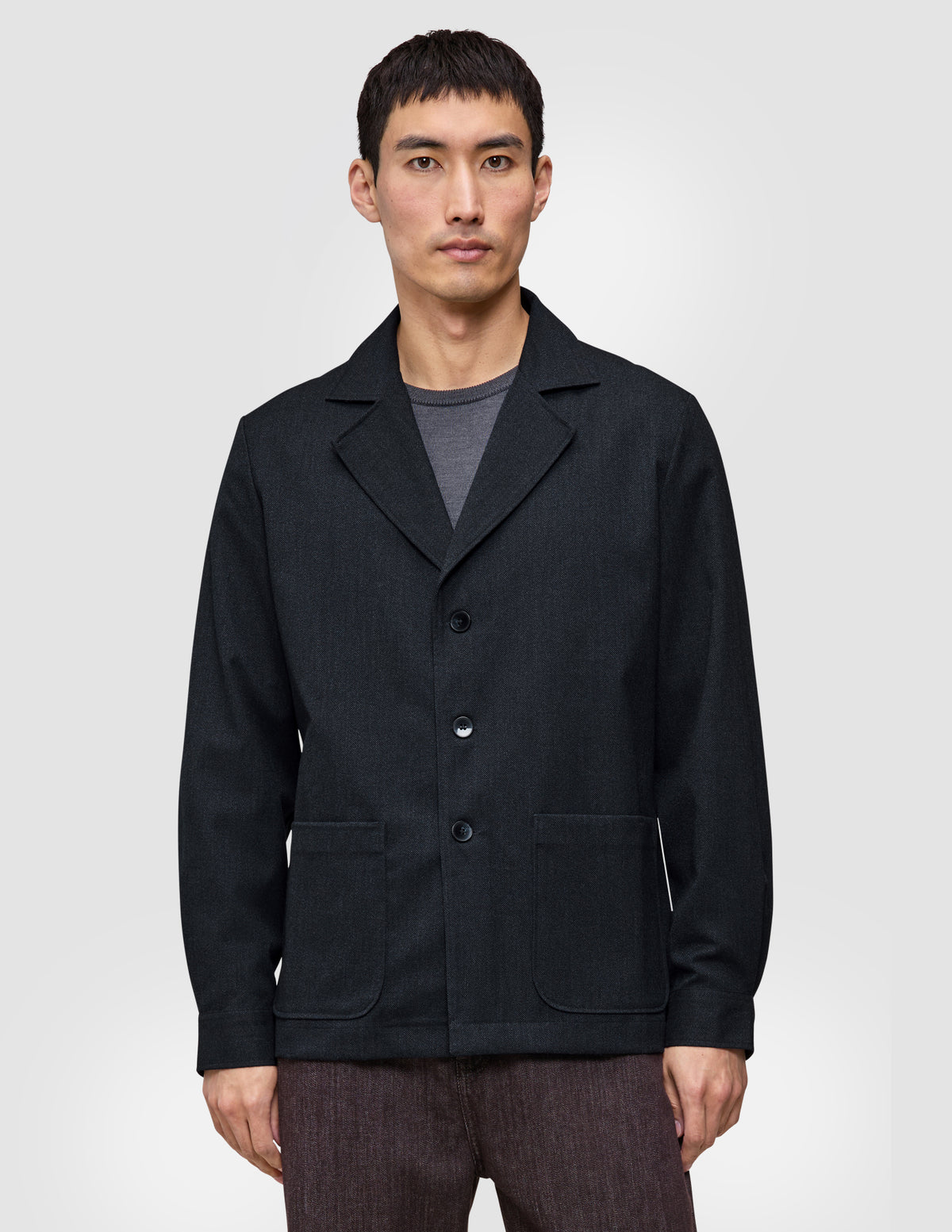 Das Atelier Overshirt Dark Navy ist ein dunkelblaues Overshirt mit gekerbtem Kragen und zwei aufgesetzten Vordertaschen, das wie ein vielseitiger Blazer gestaltet ist.