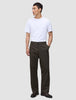 Ein Mann in einem weißen T-Shirt und einer Atelier Pants Relaxed in Dunkelbraun aus schwerem, gebrochenem Twill, die das minimalistische skandinavische Design verkörpert.