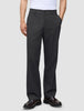 Eine Person trägt eine Atelier Pants Relaxed in Dunkelgrau aus schwerem Broken-Twill und dunkelbraune Loafer.