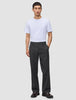 Ein Mann in einem weißen T-Shirt und einer Atelier Pants Relaxed in Dunkelgrau aus schwerem Broken-Twill, der vor einem einfarbigen Hintergrund steht.