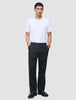 Ein Mann, der ein weißes T-Shirt mit Rundhalsausschnitt und eine Atelier Pants Relaxed Dark Navy aus schwerem, gebrochenem Twill trägt.