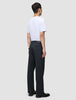 Ein Mann, von hinten gesehen, der ein weißes T-Shirt und eine Atelier Pants Relaxed Dark Navy aus schwerem, gebrochenem Twill trägt.