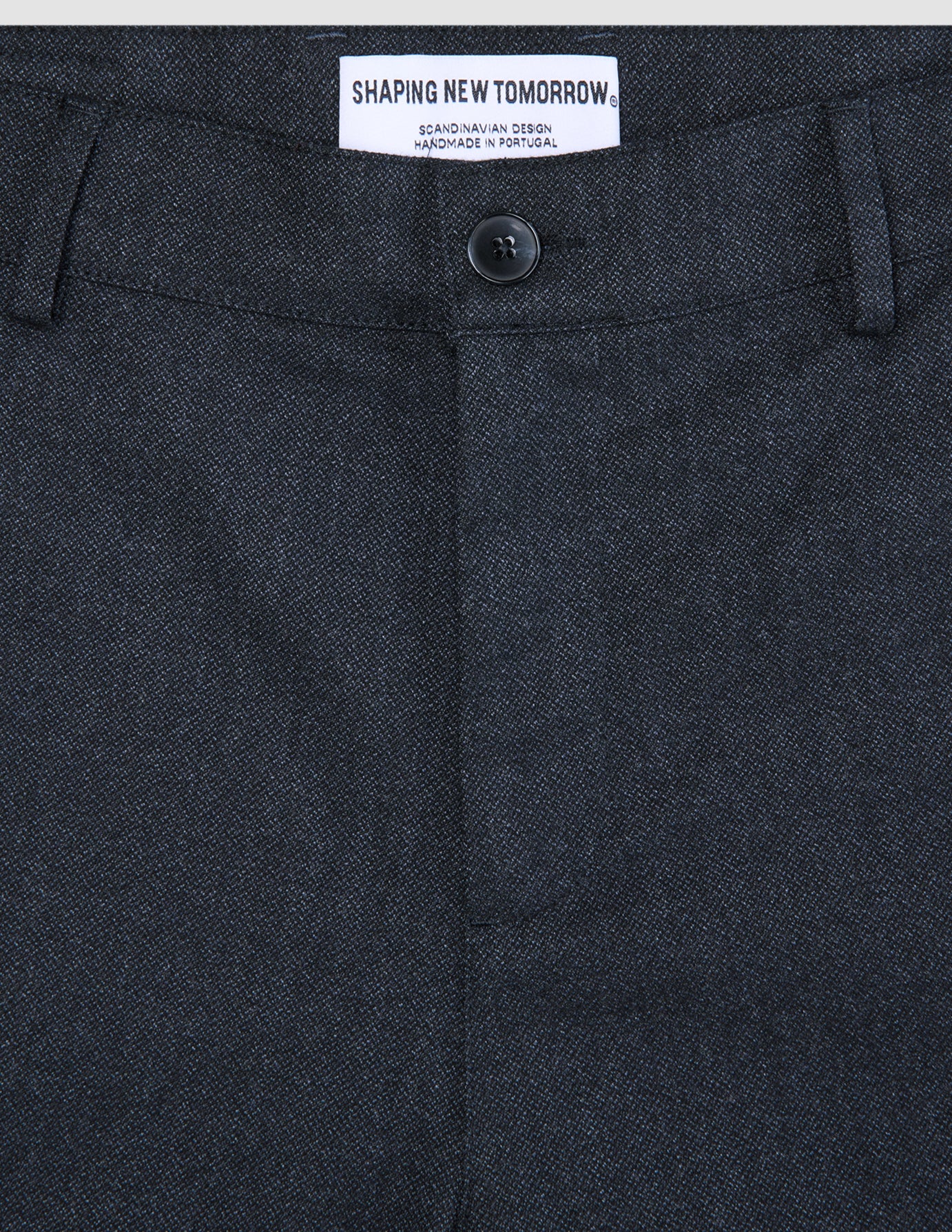 Atelier-Hose Relaxed in Dunkelblau aus schwerem Broken-Twill mit Knopfleiste und einem Etikett mit der Aufschrift Shaping New Tomorrow, skandinavisches Design, handgefertigt in Portugal.
