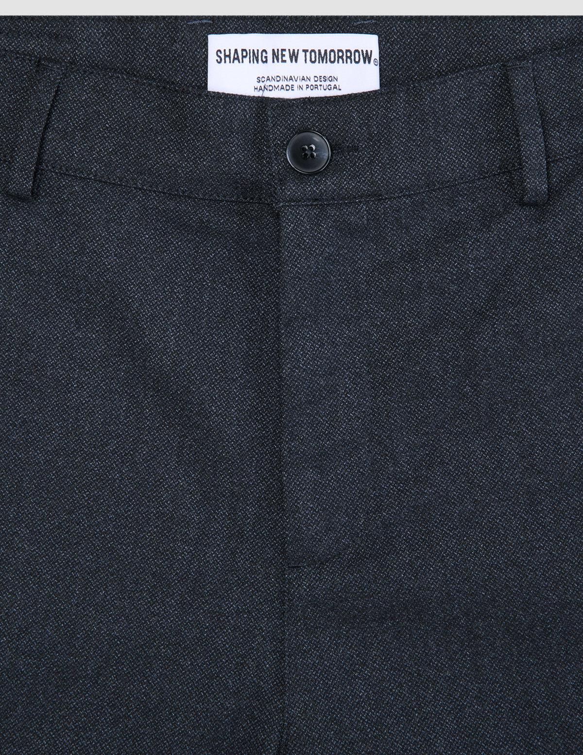 Atelier-Hose Relaxed in Dunkelblau aus schwerem Broken-Twill mit Knopfleiste und einem Etikett mit der Aufschrift Shaping New Tomorrow, skandinavisches Design, handgefertigt in Portugal.