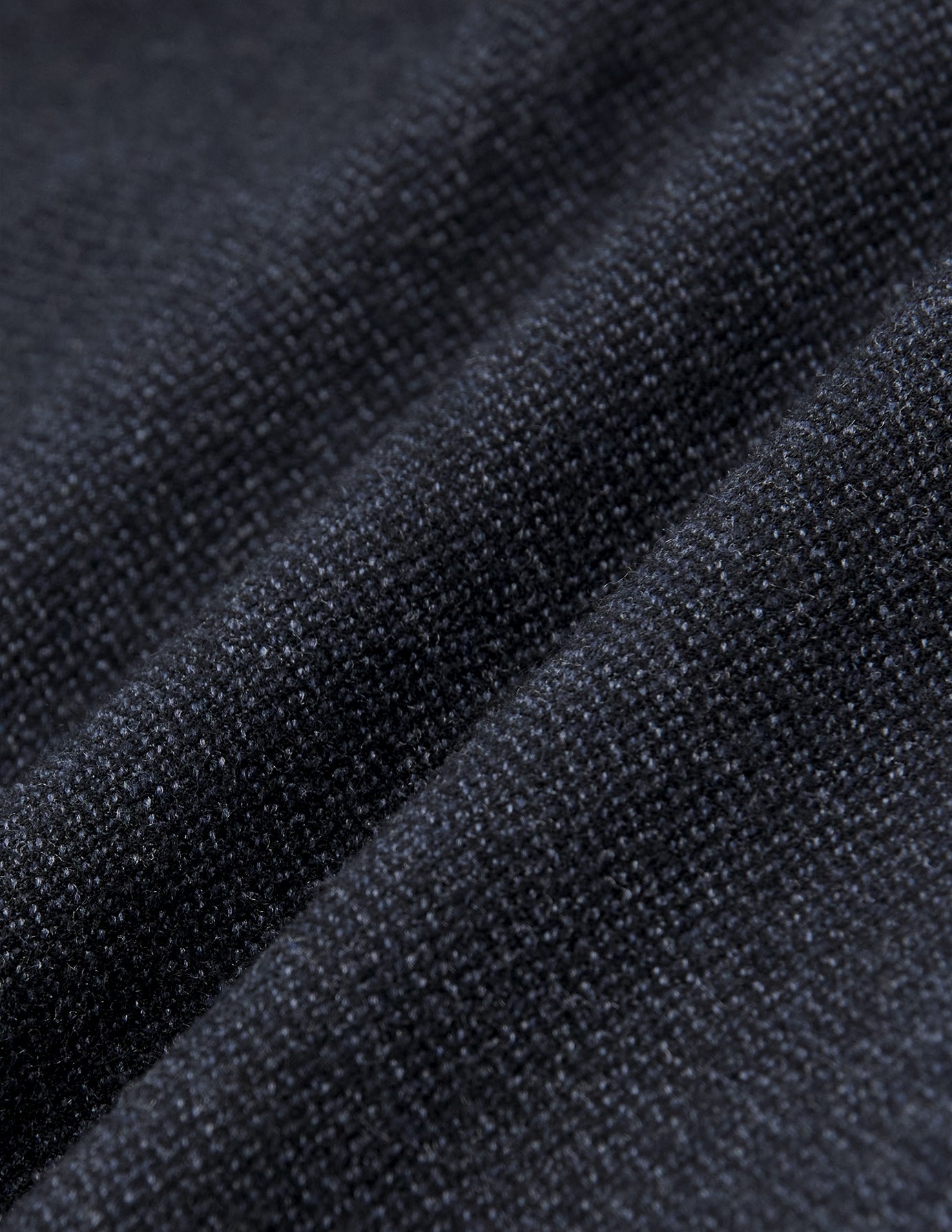 Nahaufnahme der gefalteten Atelier Pants Relaxed in Dunkelblau aus schwerem, gebrochenem Twill mit dezent strukturierter Webung.