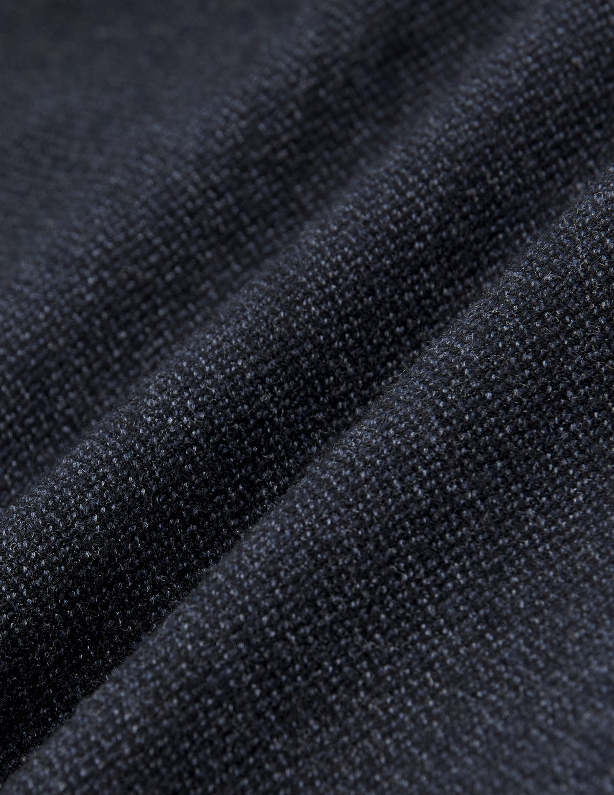 Nahaufnahme der gefalteten Atelier Pants Relaxed in Dunkelblau aus schwerem, gebrochenem Twill mit dezent strukturierter Webung.