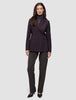 Eine Person, die einen Avira-Blazer für Damen in der Farbe Burgundy Berry im skandinavischen Zweireiher-Design über einem grauen Rollkragenpullover und einer dunklen Hose trägt.