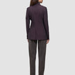 Rückansicht einer Frau, die einen dunkelburgunderroten Avira-Damenblazer in der Farbe Burgundy Berry und eine anthrazitfarbene Hose im eleganten skandinavischen Design trägt.