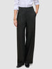 Die Damenhose Avira Pants Wide in Schwarz mit hoher Taille und weitem Bein, kombiniert mit einem weißen Hemd, das in die Hose gesteckt wurde.