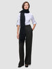 Eine Frau, die ein weißes Hemd, einen schwarzen Schal und die Damenhose Avira Pants Wide Black trägt.