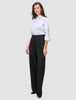 Eine Frau, die ein weißes Hemd trägt, das in eine schwarze Damenhose Avira Pants Wide mit hoher Taille gesteckt ist.
