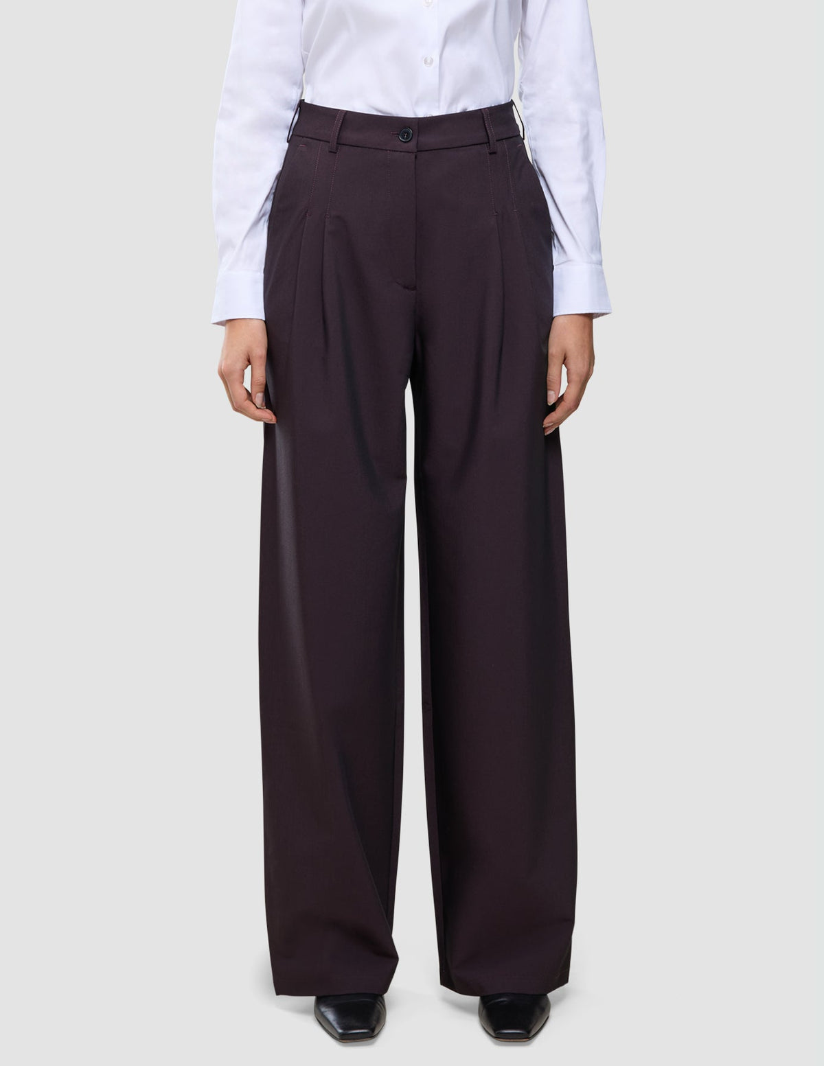 Die hoch taillierte Damenhose Avira mit weitem Bein in der Farbe Wide Burgundy Berry, kombiniert mit einem weißen Hemd.