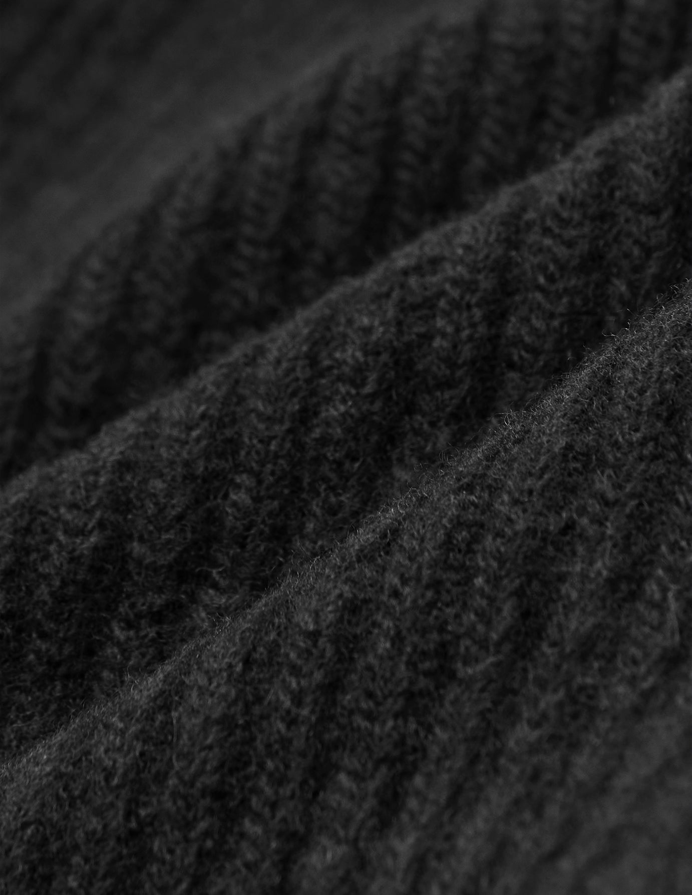 Nahaufnahme eines schwarzen, gerippten Strickstoffs auf einer schwarzen Mütze.