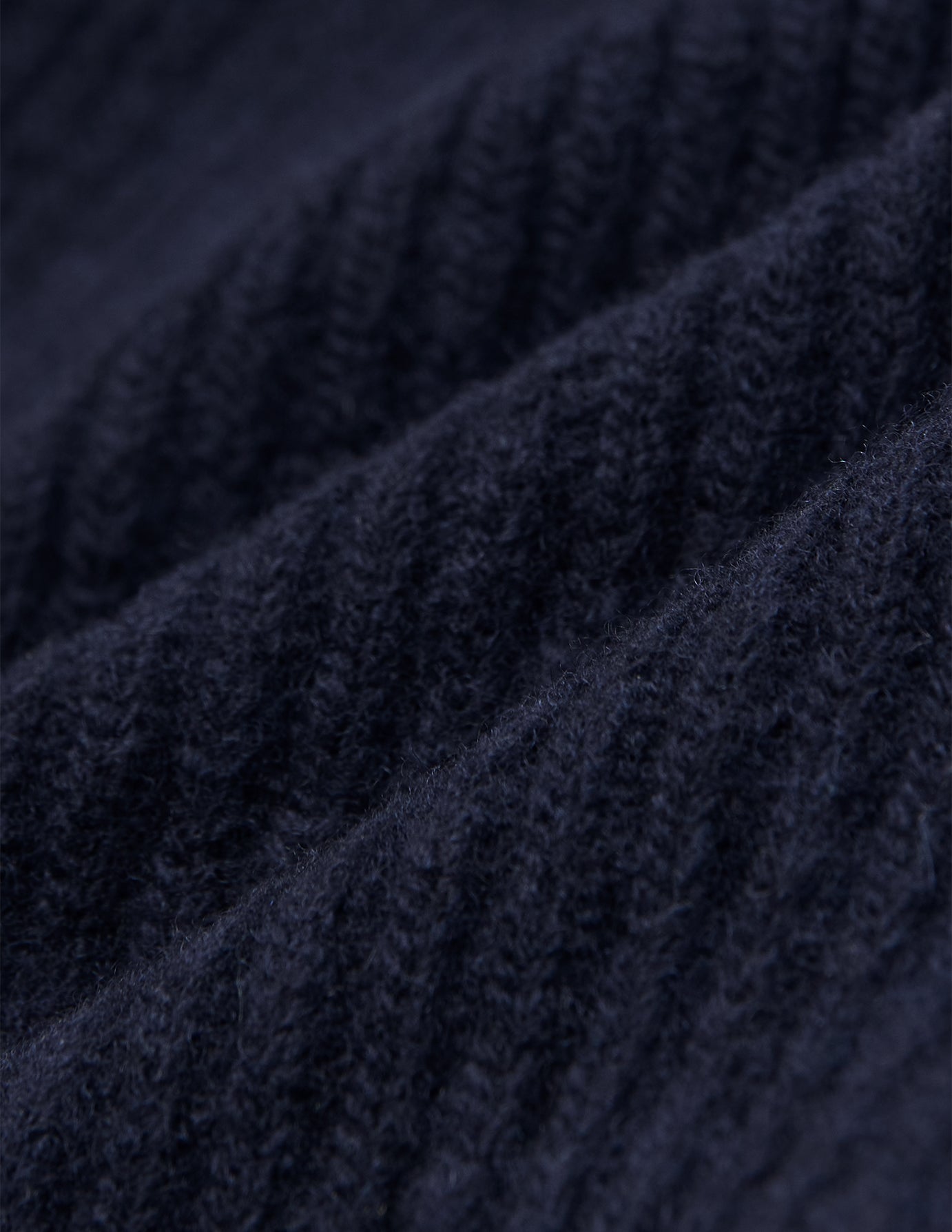 Nahaufnahme eines marineblauen, gerippten Strickstoffs auf einer Wool Beanie Navy.