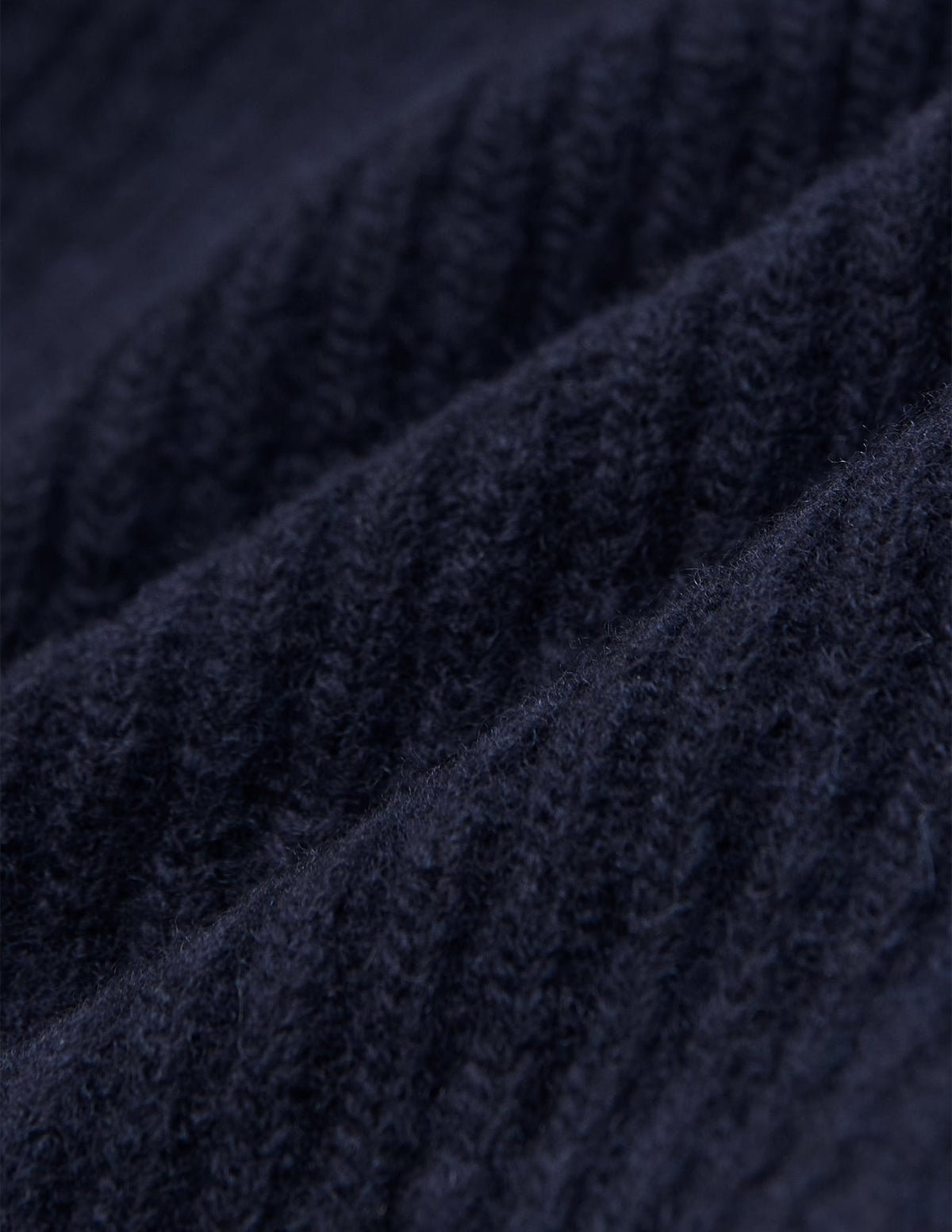 Nahaufnahme eines marineblauen, gerippten Strickstoffs auf einer Wool Beanie Navy.