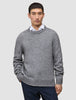 Ein Mann, der einen dicken, weichen Wollpullover mit Rundhalsausschnitt in Gletschergrau über einem weißen Hemd mit Kragen trägt.