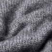 Nahaufnahme eines grauen, grob gestrickten, weichen Wollpullovers mit Rundhalsausschnitt in der Farbe Glacier Grey, der sich durch eine deutlich sichtbare Rippenstruktur auszeichnet.