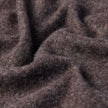 Nahaufnahme eines doppellagigen Woll-Overshirts in Sattelbraun aus dickem, braunem Stoff mit tiefen Falten.