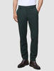Eine Person, die eine dunkelgrüne Stretchhose Ease Pants Regular Northern Pine und dunkelbraune Lederstiefel trägt.