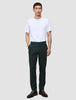 Ein Mann in einem weißen T-Shirt und einer Ease-Hose Regular Northern Pine, dazu braune Lederschuhe.