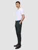 Eine Person trägt eine Ease Pants Regular Northern Pine und ein weißes T-Shirt und steht im Profil, wobei sie eine Hand in der Tasche hat.