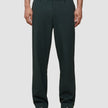 Person, die eine Ease Pants Relaxed Fit Northern Pine in lockerer Passform mit braunen Loafern trägt; die Hose verfügt über 360°-Stretch.
