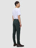 Eine Person, von hinten gesehen, die ein weißes T-Shirt und eine Ease Pants Slim Northern Pine sowie braune Lederstiefel trägt und damit das minimalistische skandinavische Design verkörpert.