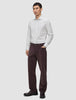 Ein Mann, der ein hellgrau gestreiftes Elevated Shirt Regular, eine dunkelbraune Hose und dunkle Slipper trägt.