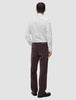 Eine Person, von hinten gesehen, die ein Elevated Shirt Regular in hellgrau gestreift, eine dunkelbraune Hose und dunkle Schuhe trägt.