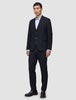 Ein Mann trägt einen Motion Blazer Regular in Mitternachtsblau mit 360°-Stretch und eine dazu passende Hose über einem hellblauen Hemd, dazu dunkle Loafer.
