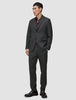 Ein Mann trägt einen Motion Blazer Regular in der Farbe Pepper Grey mit einer dazu passenden Hose, einem dunklen Hemd mit Knopfleiste und braunen Loafern, die das minimalistische skandinavische Design unterstreichen.