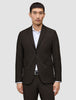 Ein Mann, der einen Motion Blazer Slim Cognac trägt, einen dunkelbraunen Slim-Fit-Blazer mit 360°-Stretch, über einem weißen Hemd mit Knopfleiste.