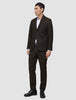 Ein Mann, der einen dunkelbraunen Motion Blazer Slim Cognac, ein weißes Hemd und schwarze Anzugschuhe trägt.