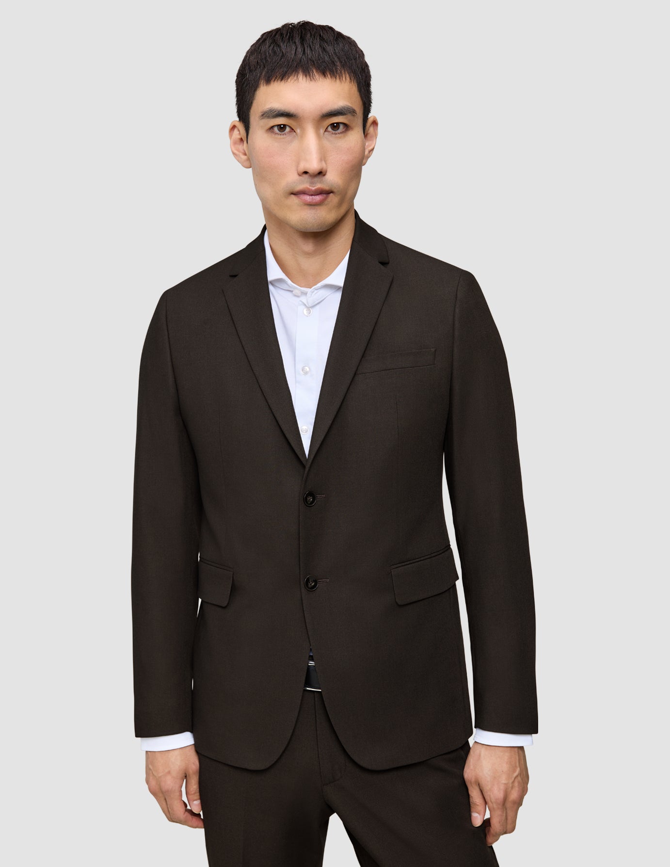 Ein Mann, der einen Motion Blazer Slim Cognac mit skandinavischem Design über einem weißen Hemd trägt.