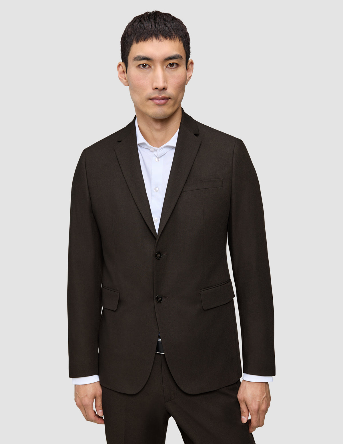 Ein Mann, der einen Motion Blazer Slim Cognac mit skandinavischem Design über einem weißen Hemd trägt.