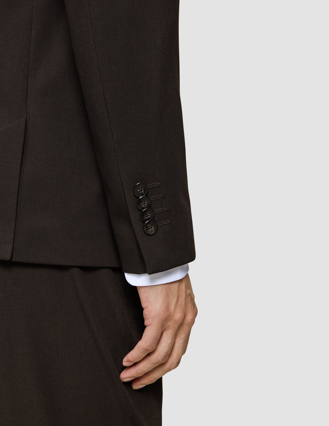 Nahaufnahme eines braunen Ärmels des Motion Blazer Slim Cognac mit vier schwarzen Knöpfen am Ärmelbund und einem darunter sichtbaren weißen Hemdärmelbund.