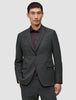 Ein Mann, der einen Motion Blazer Slim in der Farbe Pepper Grey über einem dunklen Hemd mit Knöpfen trägt und damit skandinavisches Design zur Geltung bringt.