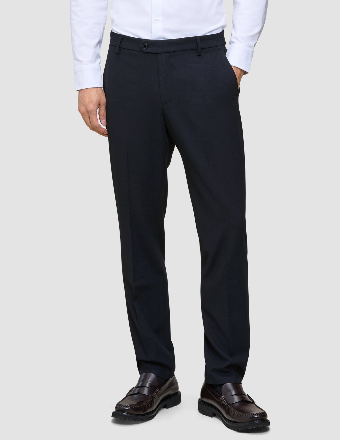 Atmungsaktive Motion Suit-Hose in Regular-Passform, mitternachtsblau, mit 360°-Stretch, kombiniert mit einem hellen Hemd und dunklen Loafern.