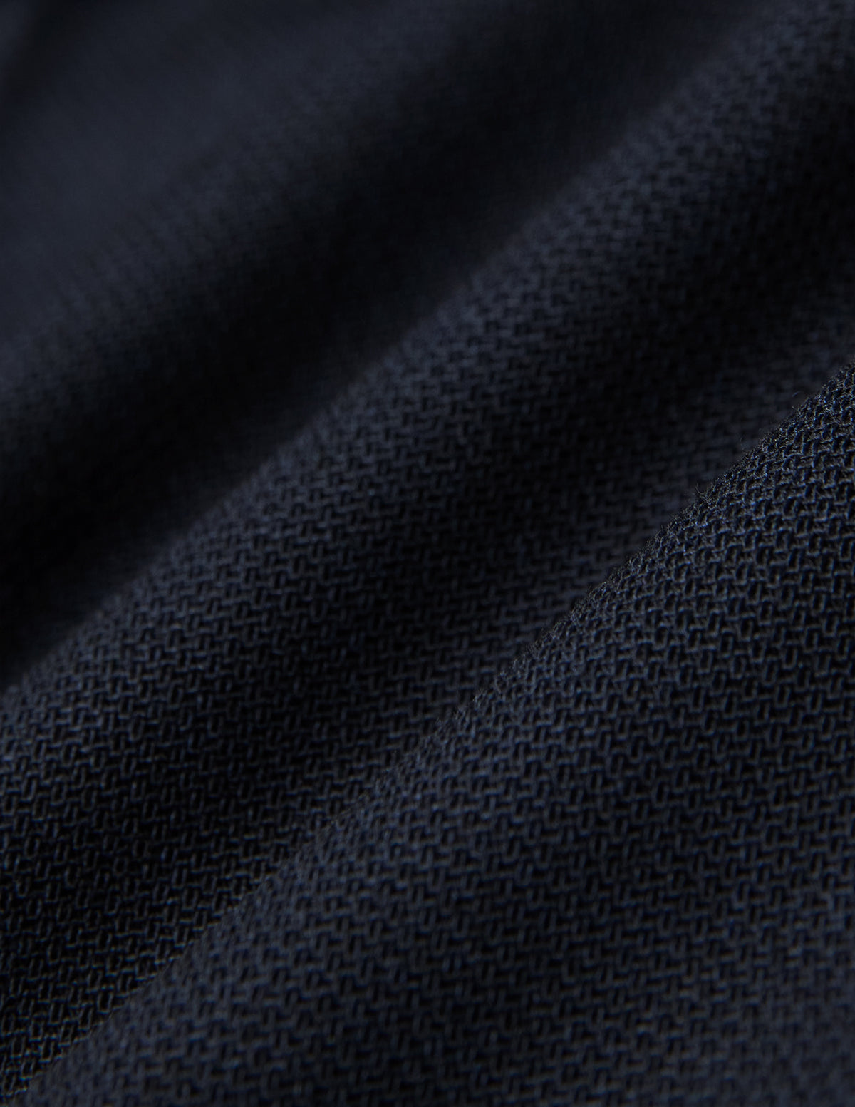 Nahaufnahme einer gefalteten Motion Suit-Hose in der Passform Regular in Mitternachtsblau mit einer sichtbaren, gewebten 360°-Stretch-Struktur.