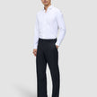 Ein Mann, der ein weißes Hemd und eine Motion Suit-Hose im Relaxed-Schnitt in Mitternachtsblau trägt.