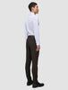 Ein Mann steht im Profil da und trägt ein weißes Hemd sowie eine Motion Suit Pants Slim Cognac – ein eleganter Look.
