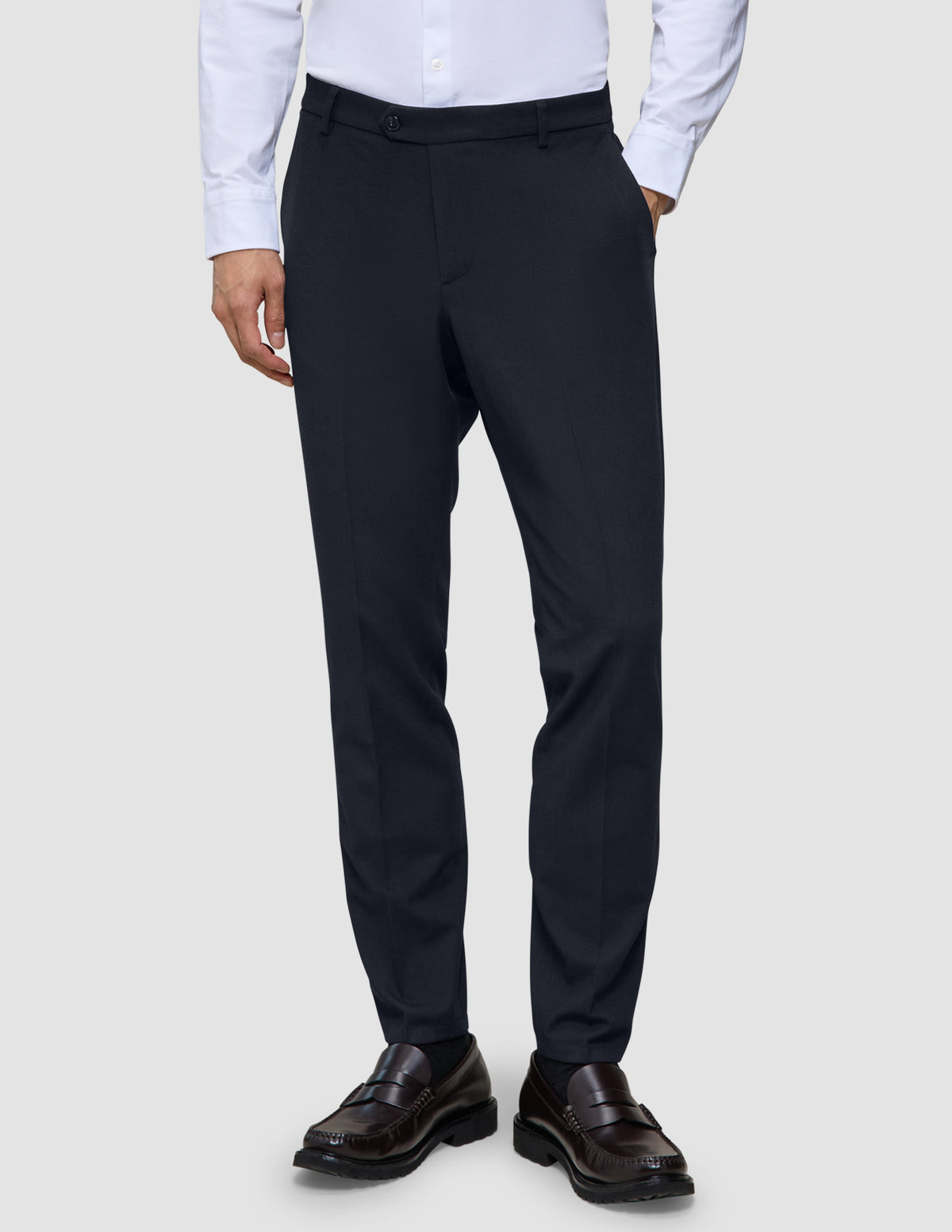 Motion-Anzughose, Slim-Fit, mitternachtsblau, kombiniert mit einem hellen Hemd und dunklen Loafern.