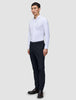 Ein Mann, der ein weißes, langärmeliges Hemd mit Knöpfen und eine Motion Suit Pants Slim in Mitternachtsblau trägt.