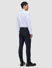 Eine Person, von hinten gesehen, die ein weißes Hemd und eine Motion Suit Pants Slim in Mitternachtsblau sowie dunkle Loafer trägt.